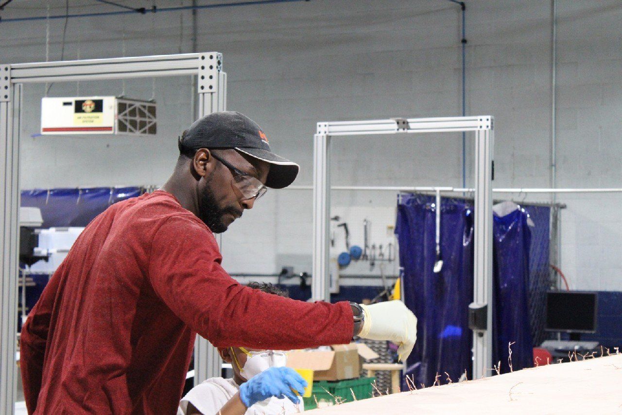 Charles is applying materials to the Row4Kids boat