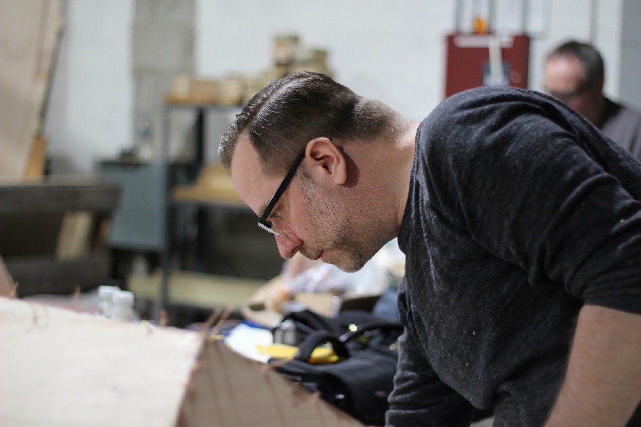 Jake is applying materials to the Row4Kids boat