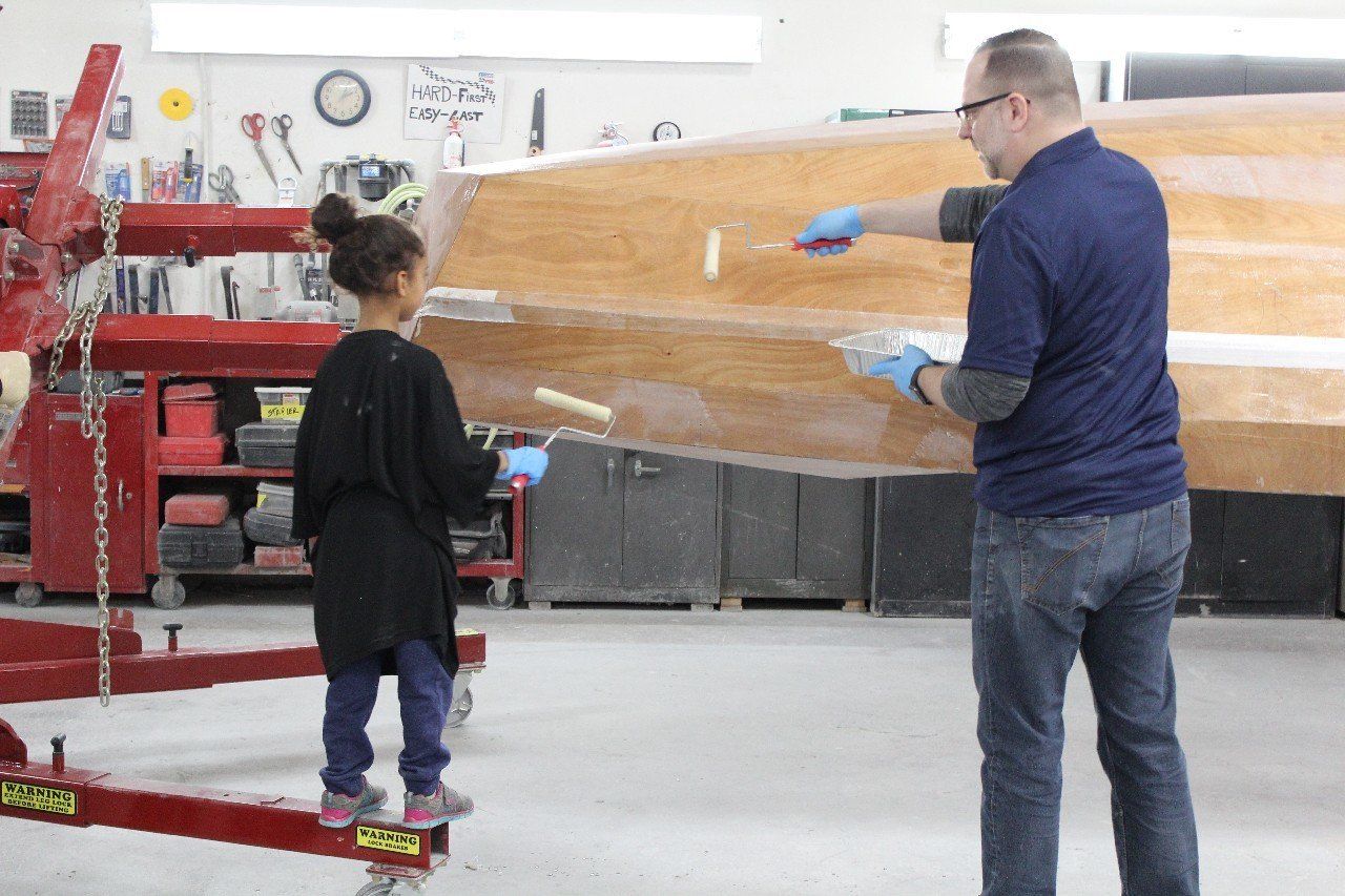 Jake applies materials to the Row4Kids boat