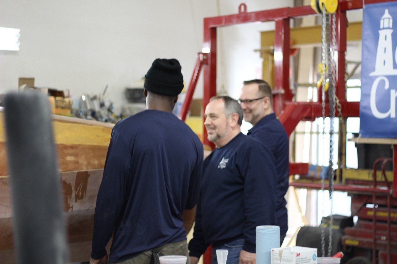 Keith is discussing the Row4Kids boat build with Charles and Jake