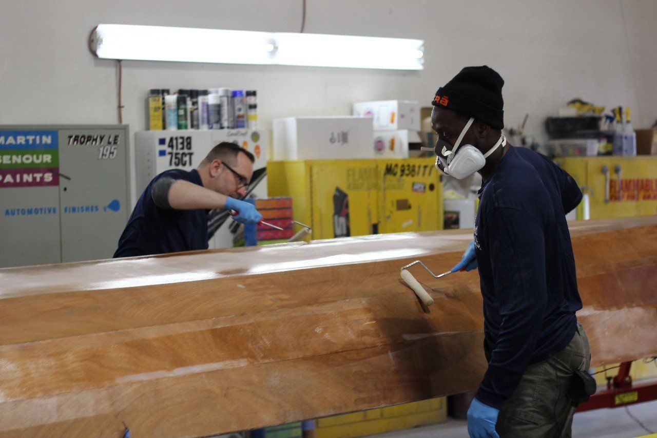 Jake and Charles apply materials to the Row4Kids boat