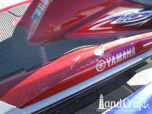 Red Yamaha with fiberglass damage and scratches along rear gunnel