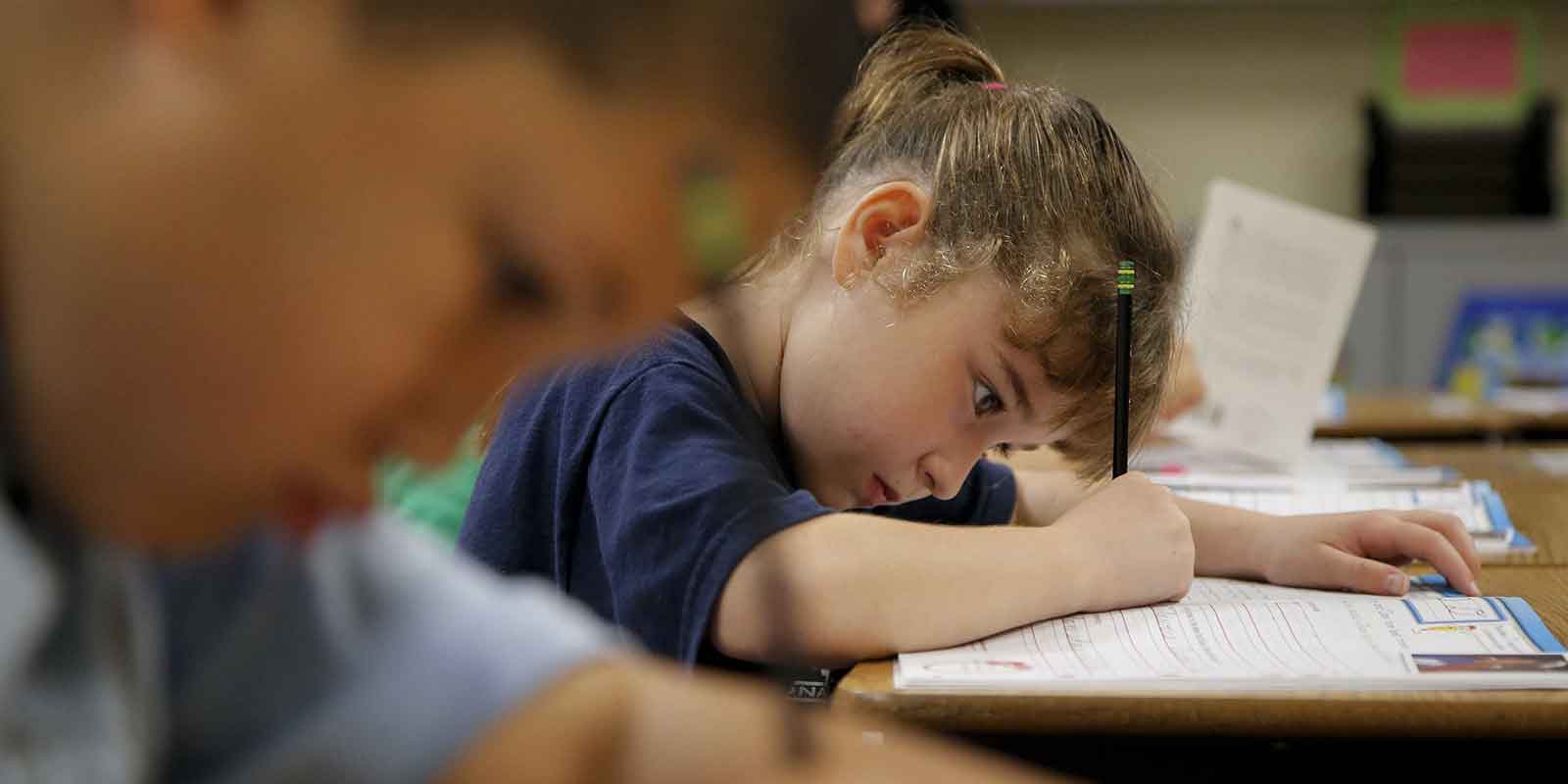 The Importance of Penmanship in Children: A little girl is using a pencil and paper to practice writing sentences correctly.