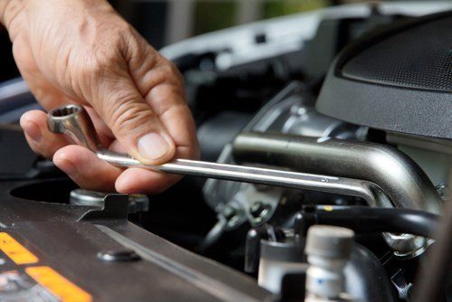 tecnico con chiave ad anello durante riparazione auto