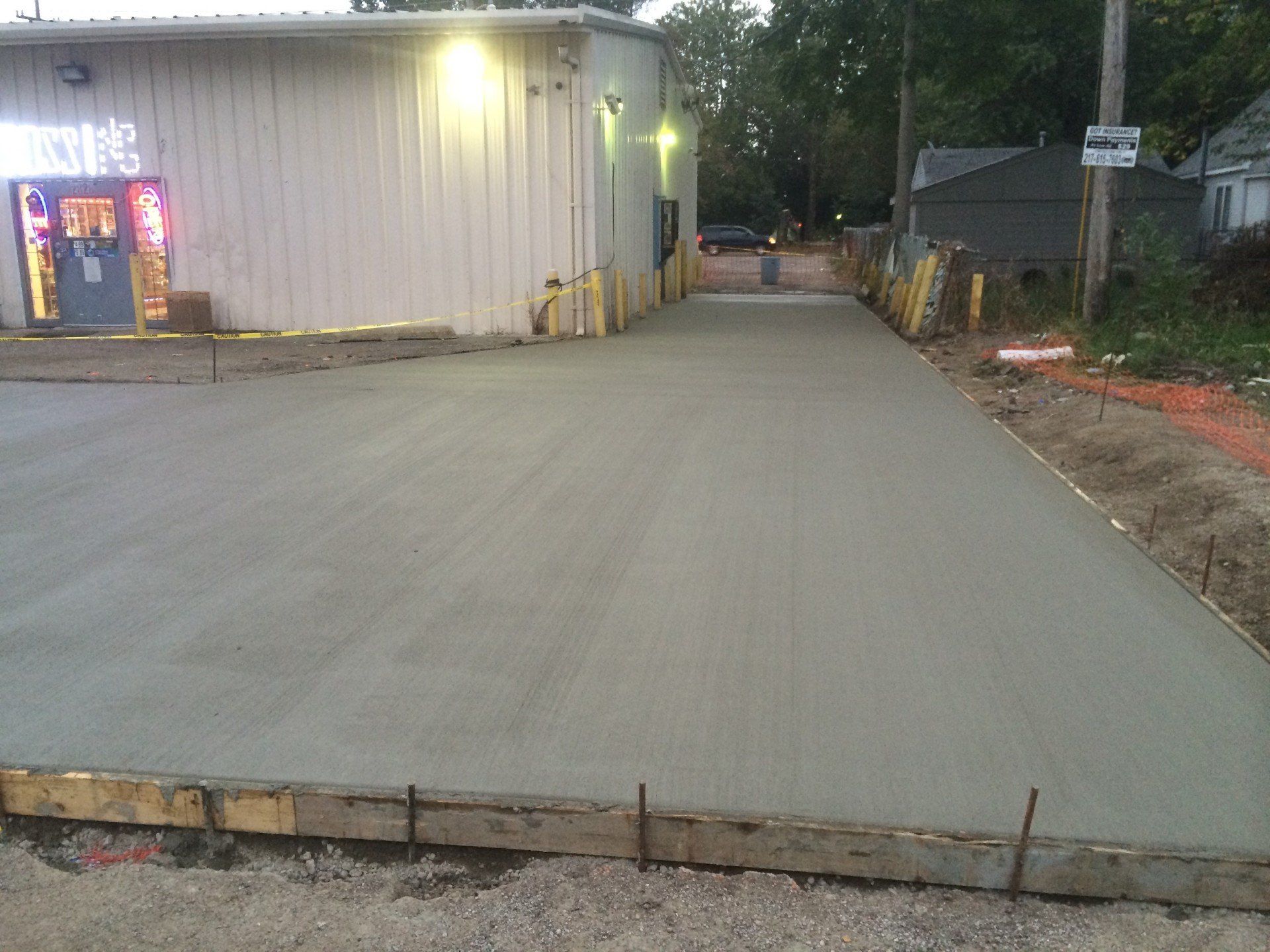 Newly poured concrete driveway next to a building.