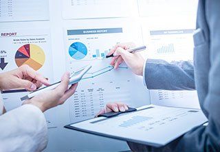 Business people discussing the charts and graphs showing the results of their successful teamwork