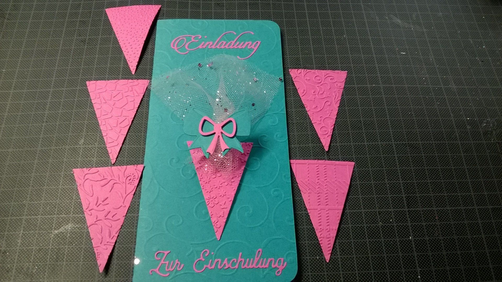 Eine blau-rosa Einladung mit rosa Dreiecken darum