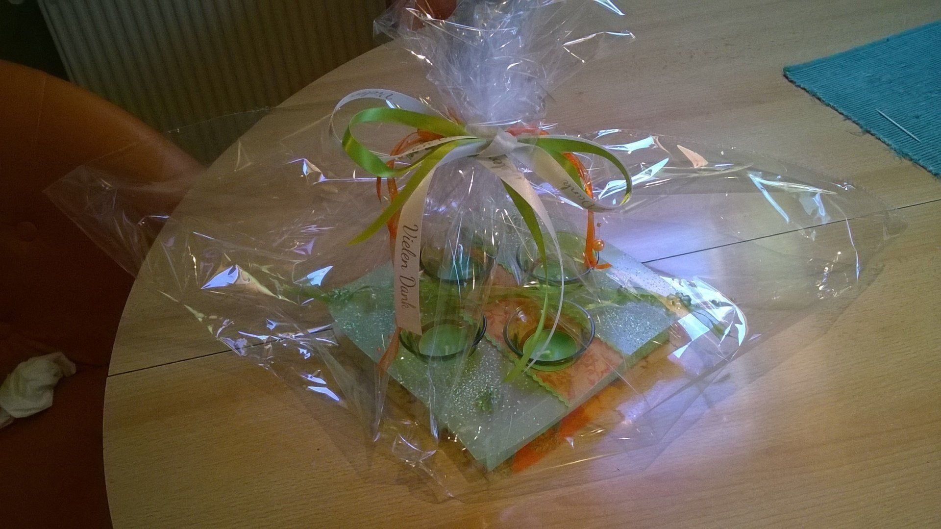 Ein verpacktes Geschenk liegt auf einem Holztisch.