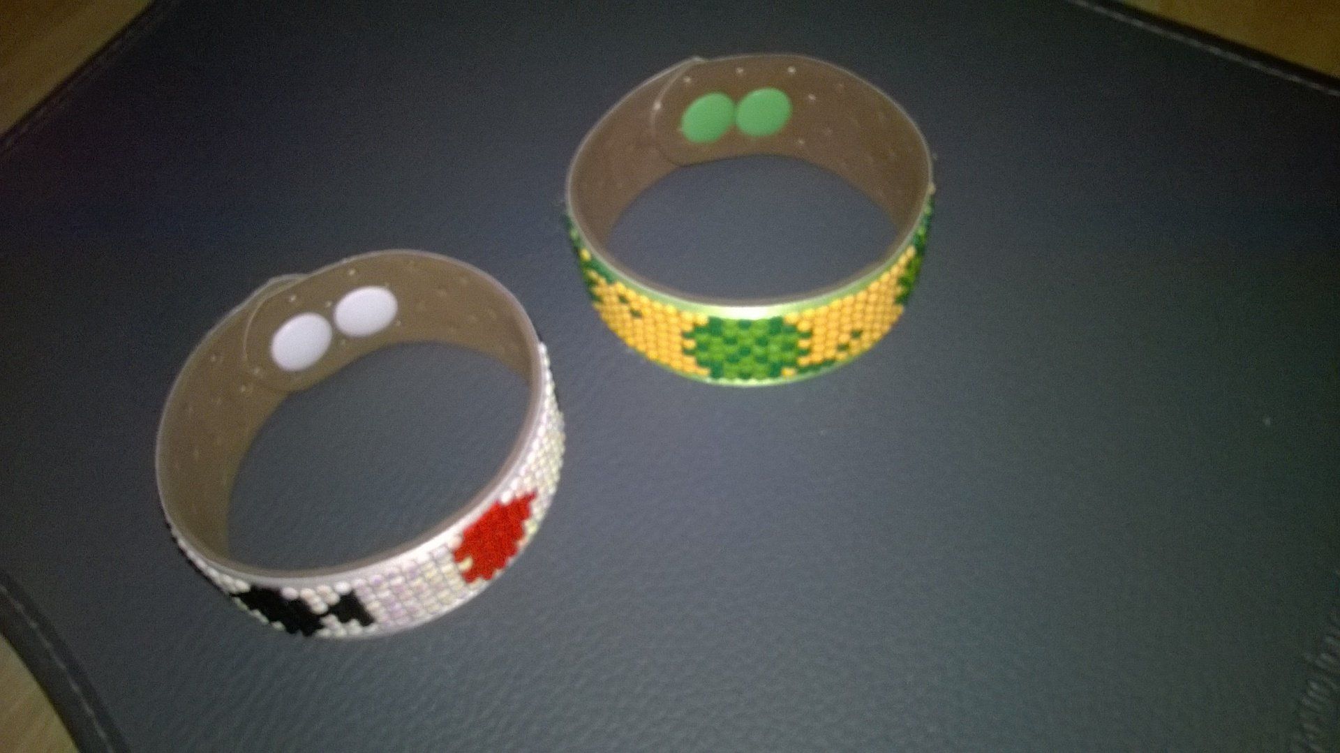 Zwei Perlenarmbänder liegen auf einer schwarzen Oberfläche