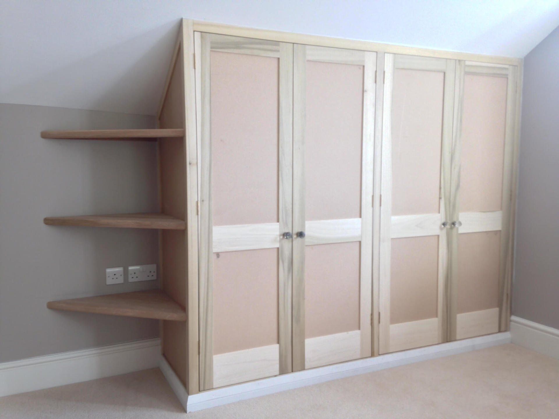 Wardrobe to sloped ceiling with Traditional joinery made tulipwood doors.