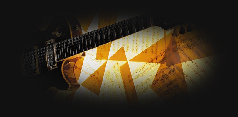 The neck of a guitar against scattered sheet music