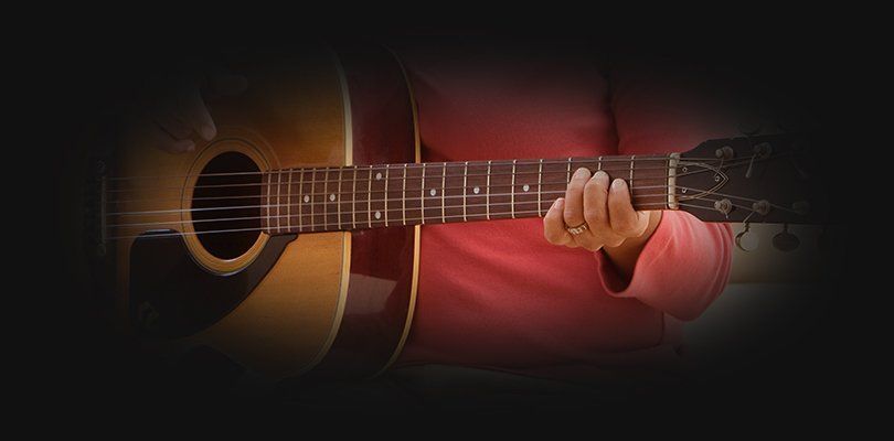 A man holding an acoistic guitar
