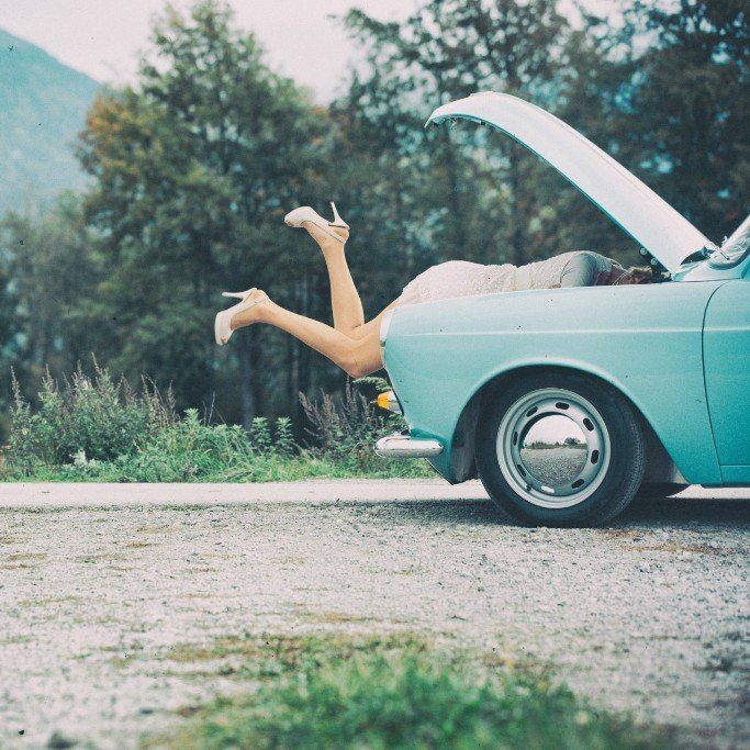 women's legs in white high heels sticking out of blue vintage boot of car, Cotswold Tiger, The Second Home Company