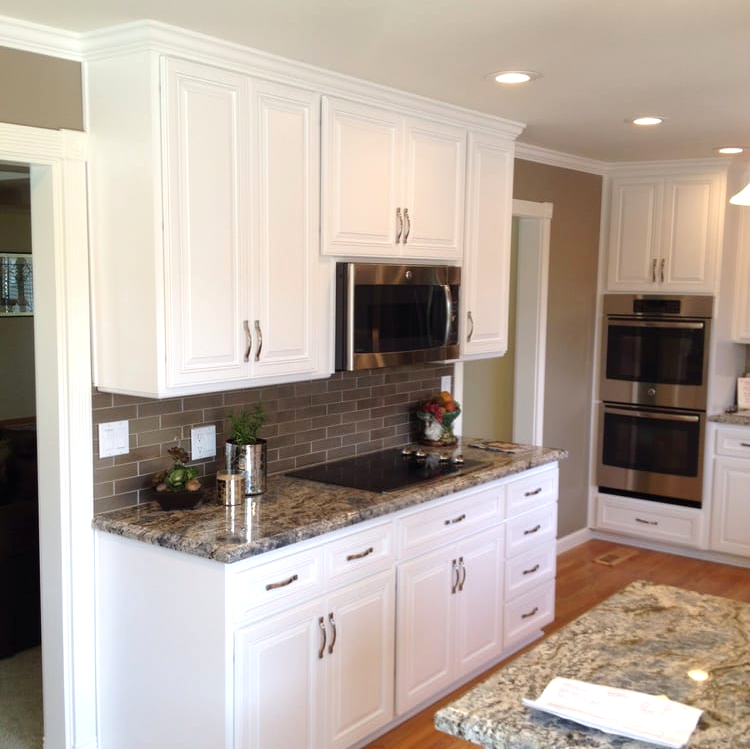 A kitchen with white cabinets and granite counter tops