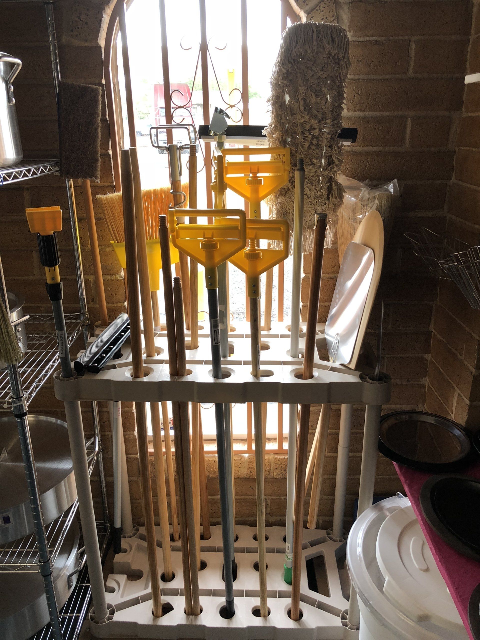 A bunch of mop handles are lined up in a rack