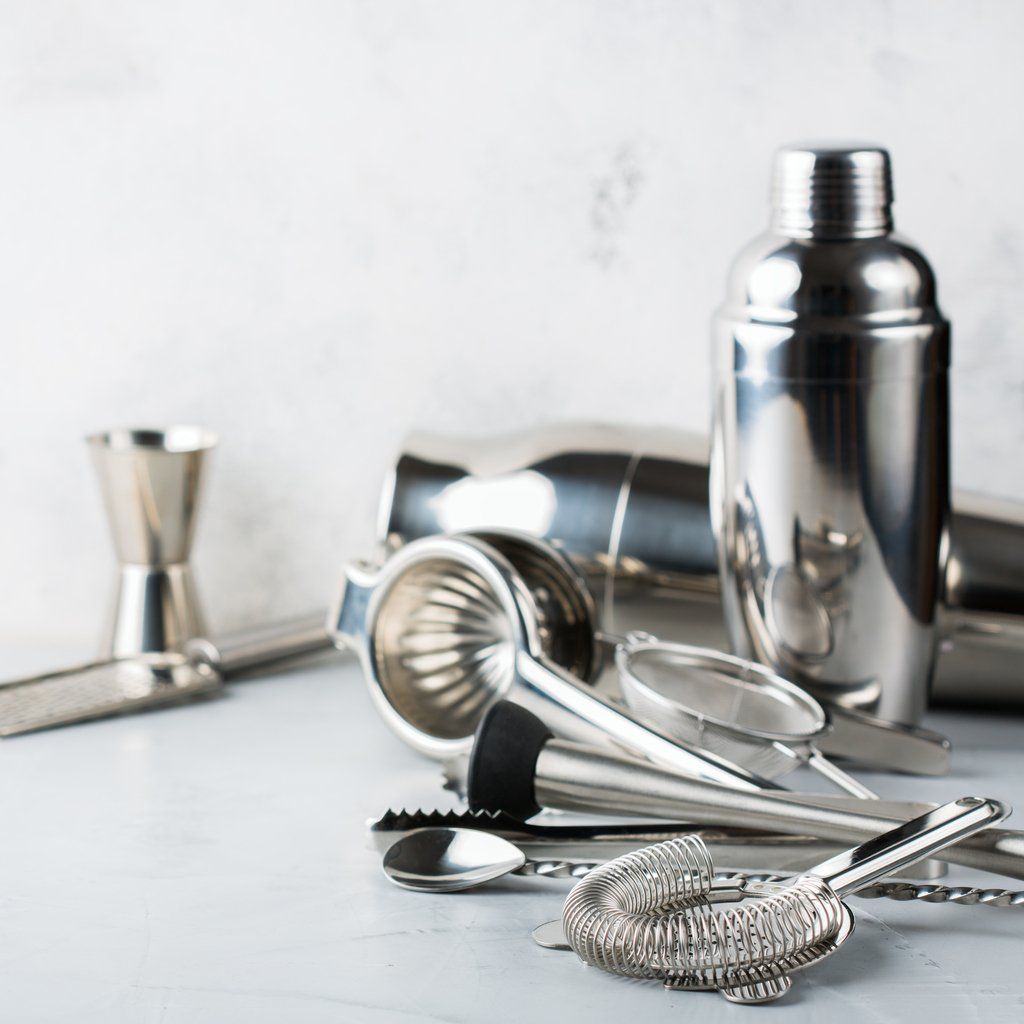 A bunch of stainless steel bar supplies are sitting on a table.