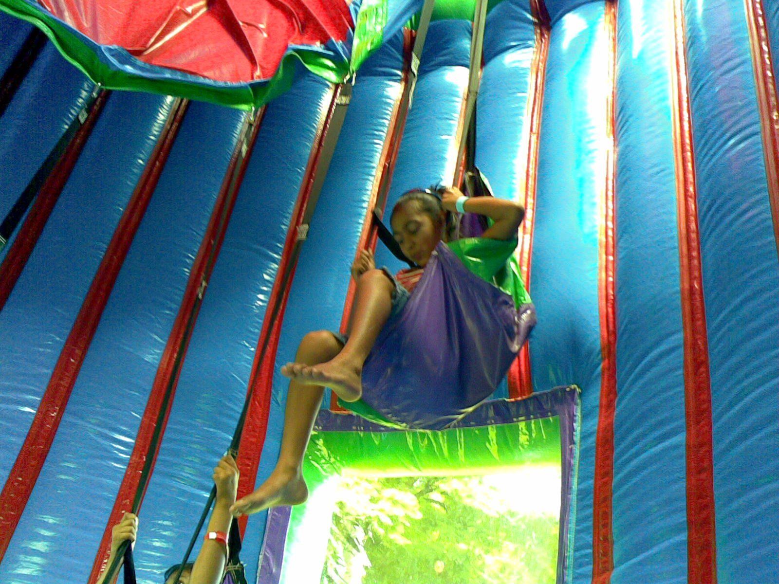 A girl in a purple dress is sitting on a slide