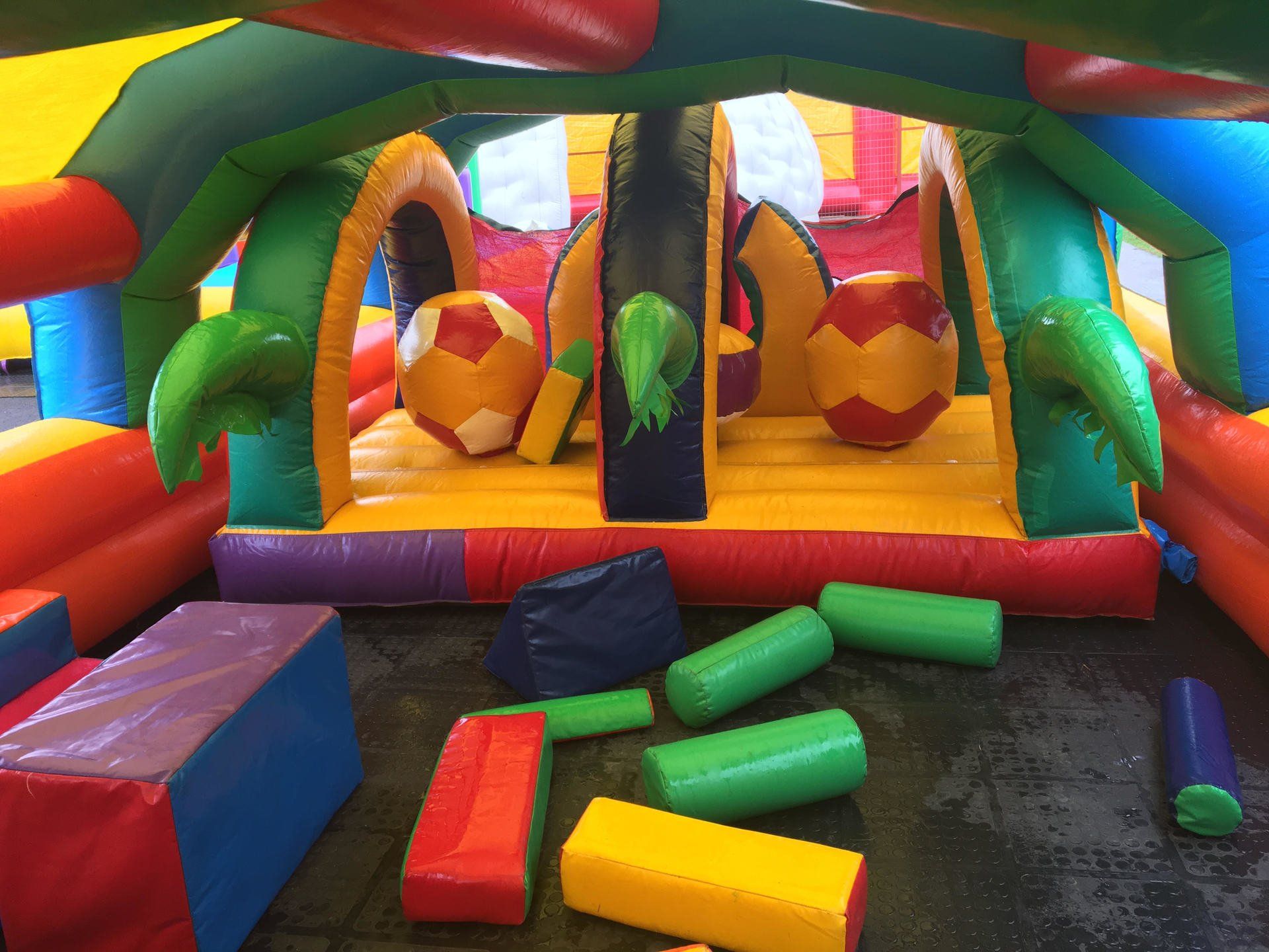 A colorful bouncy house with a lot of foam blocks on the floor.