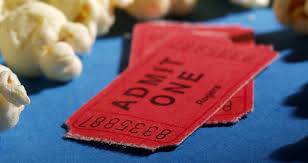 Two red admit one tickets are sitting on a blue table next to popcorn.