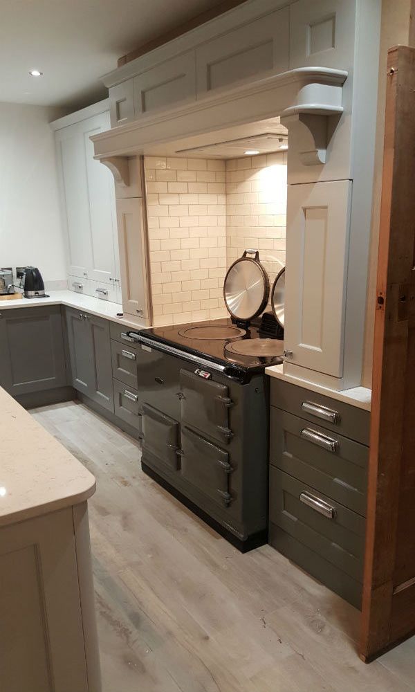 Modern galley kitchen with dark cabinets and stone worktops.