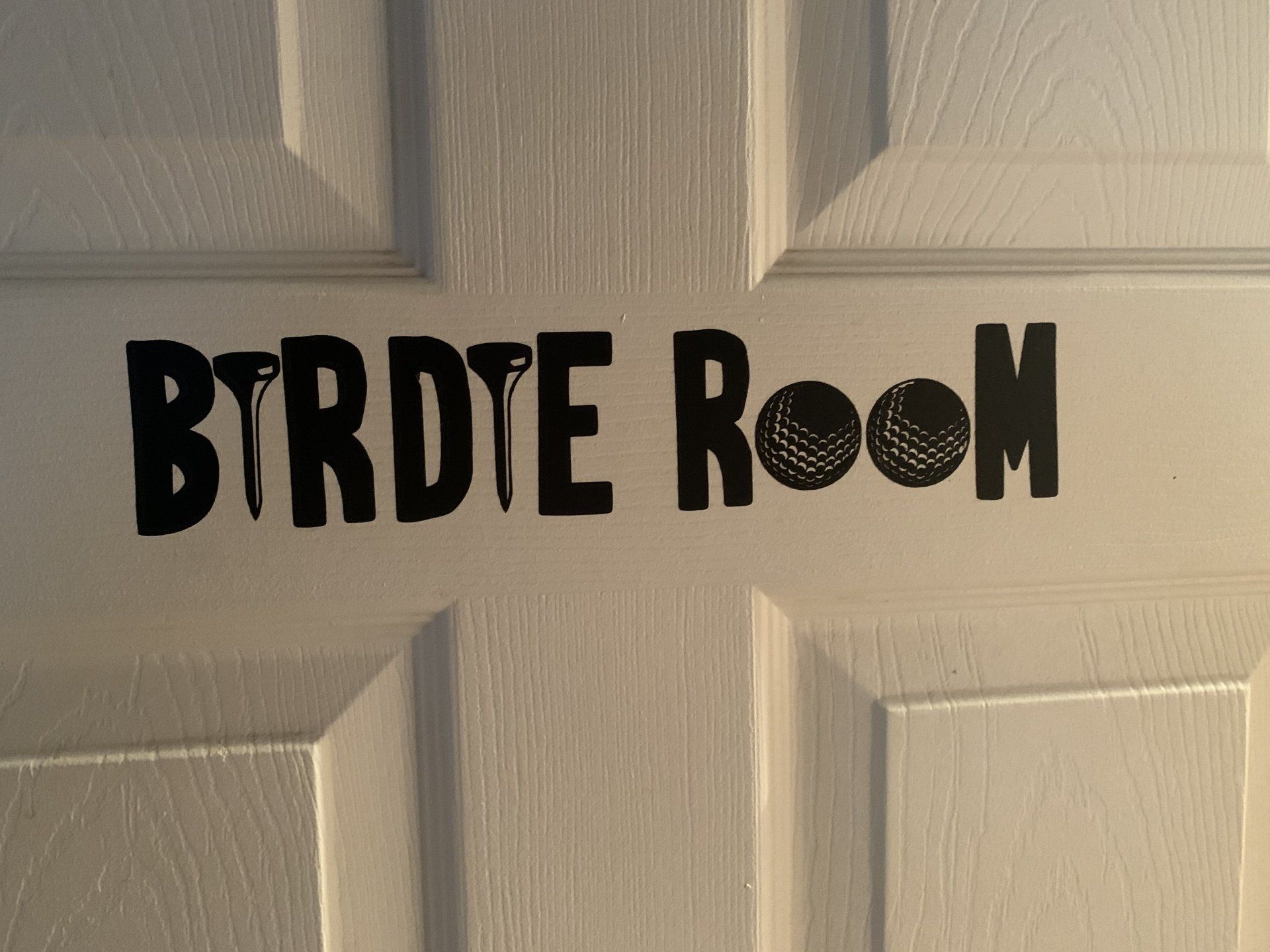 Black vinyl lettering on a white door reads 