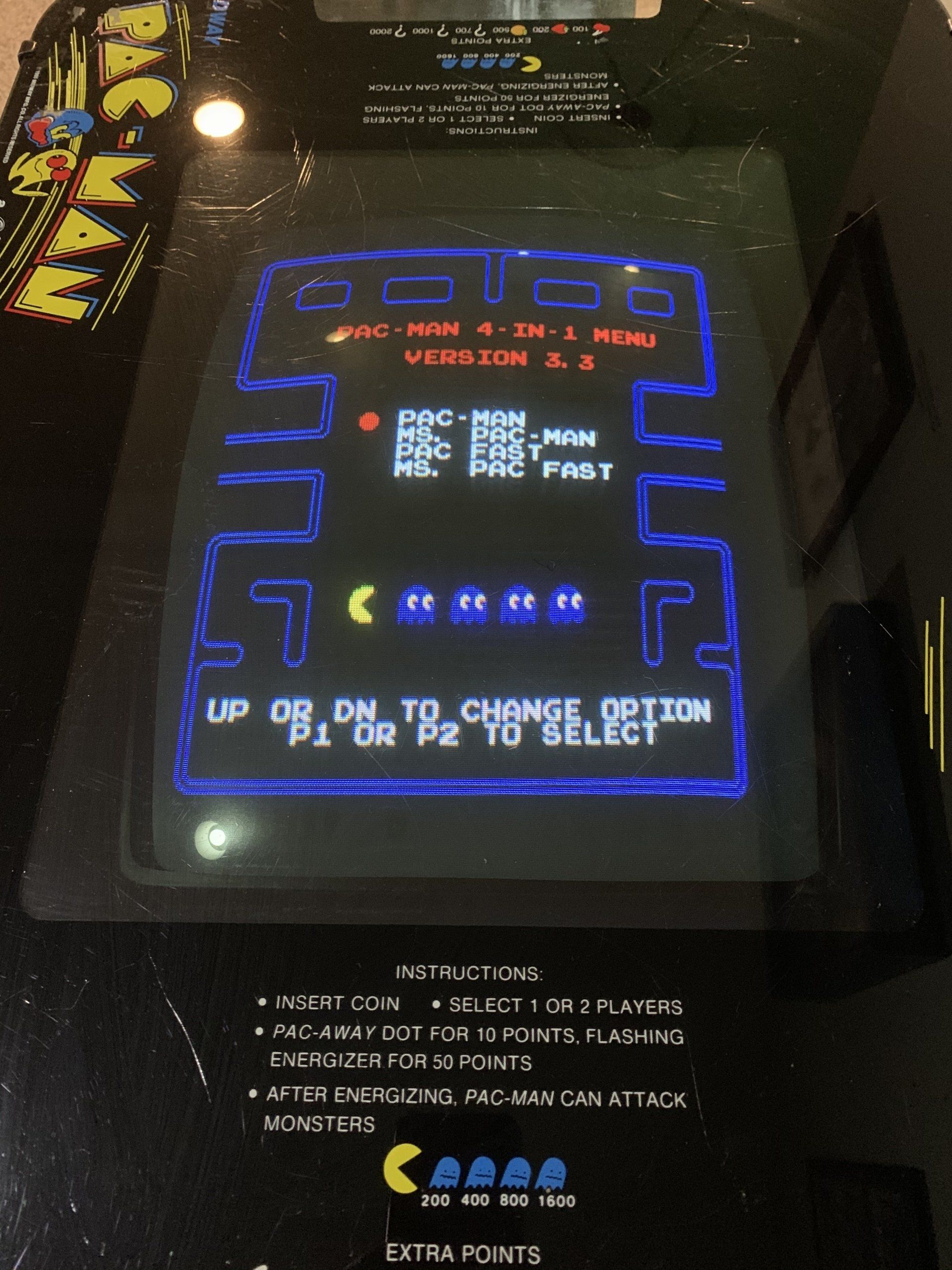Pac-Man arcade game screen displaying menu options: ROM, PAC FAST, etc. with instructions.