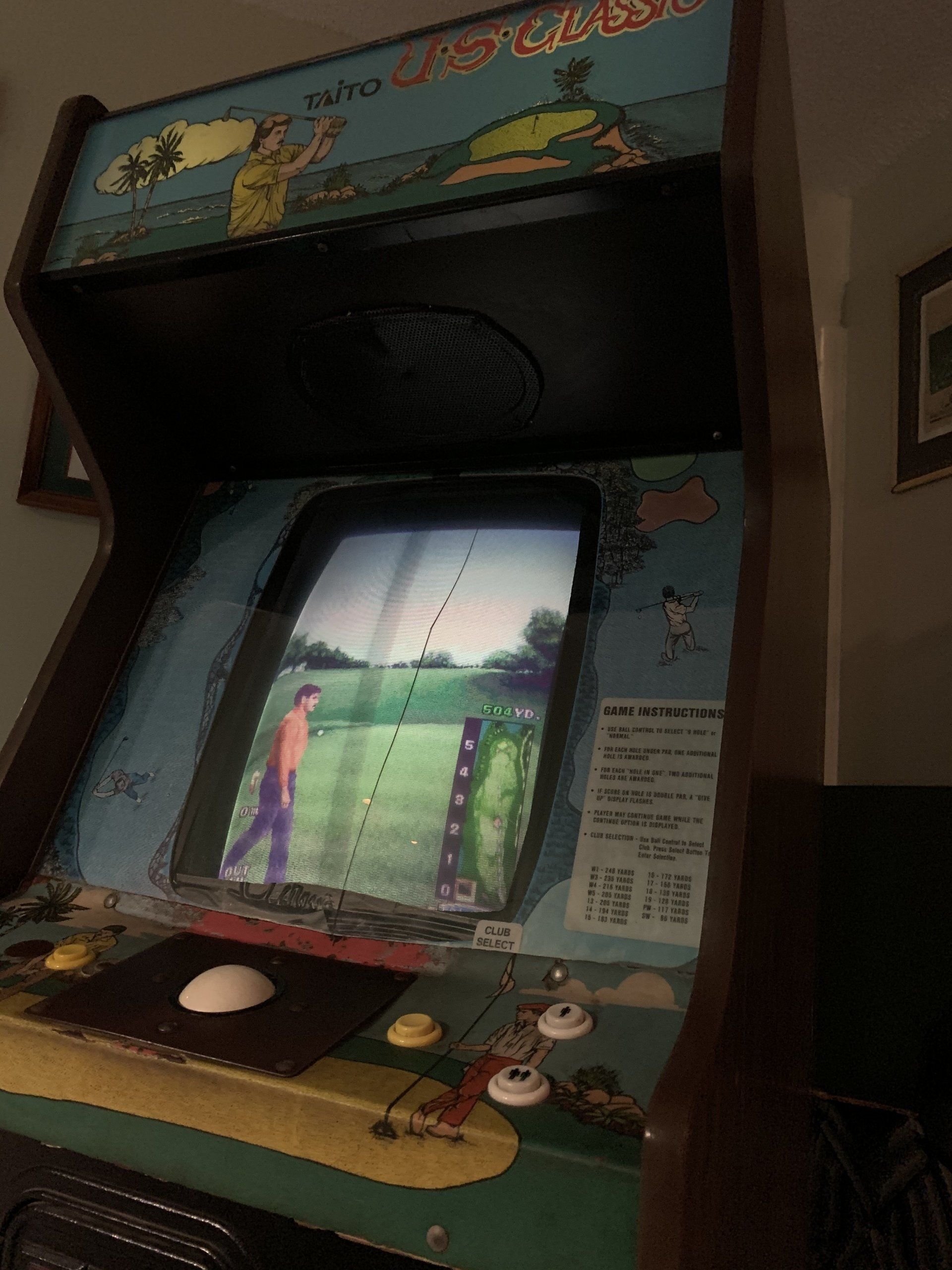 Arcade golf game; player about to swing. Dark wood cabinet, green grass on screen.