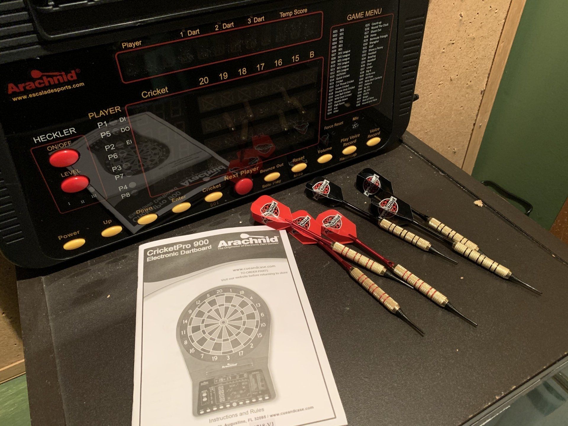 Dart board setup: Electronic dartboard, darts, manual, and black control unit.