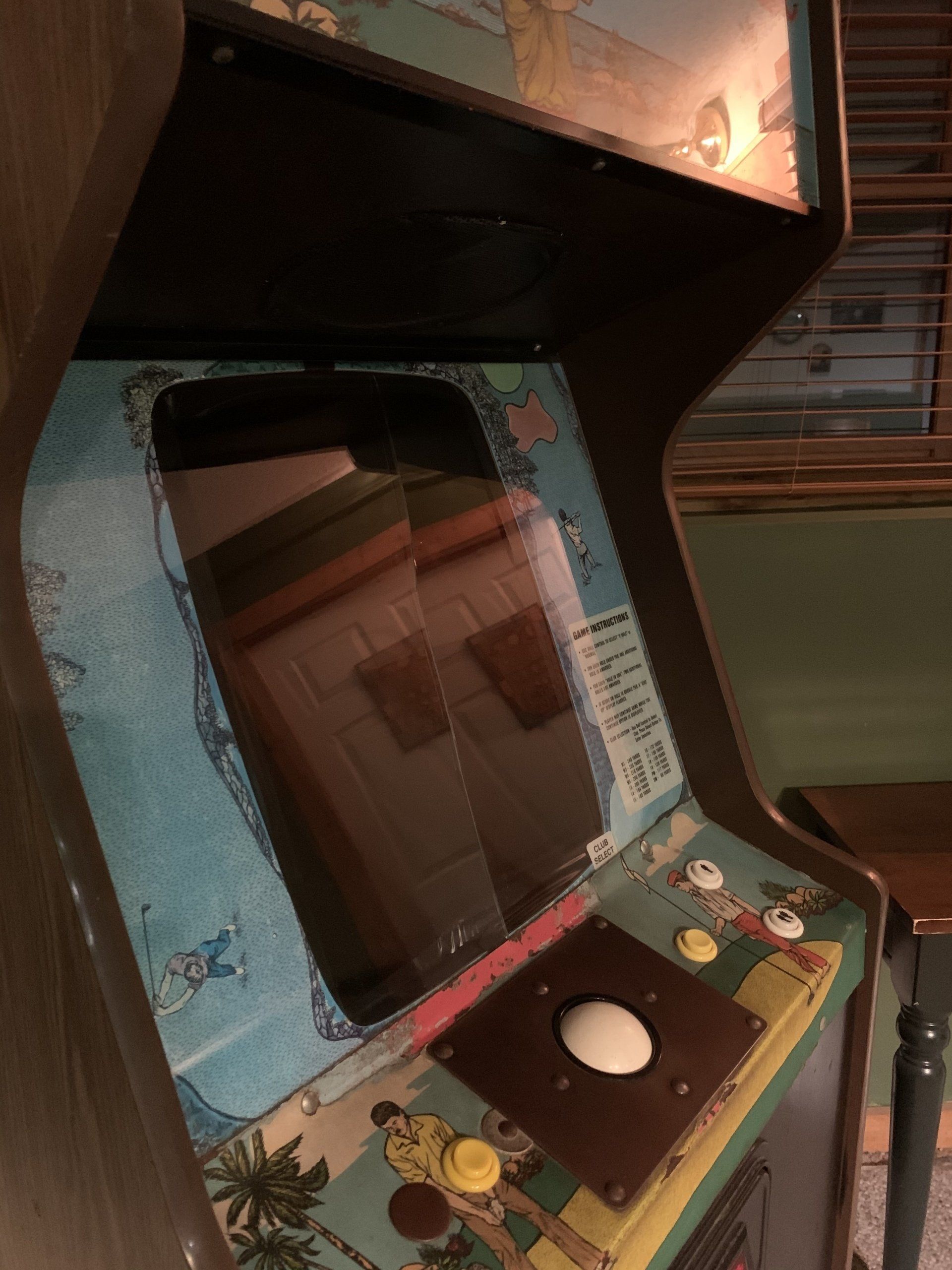 Arcade cabinet with a light blue and brown color scheme, featuring a screen and joystick.