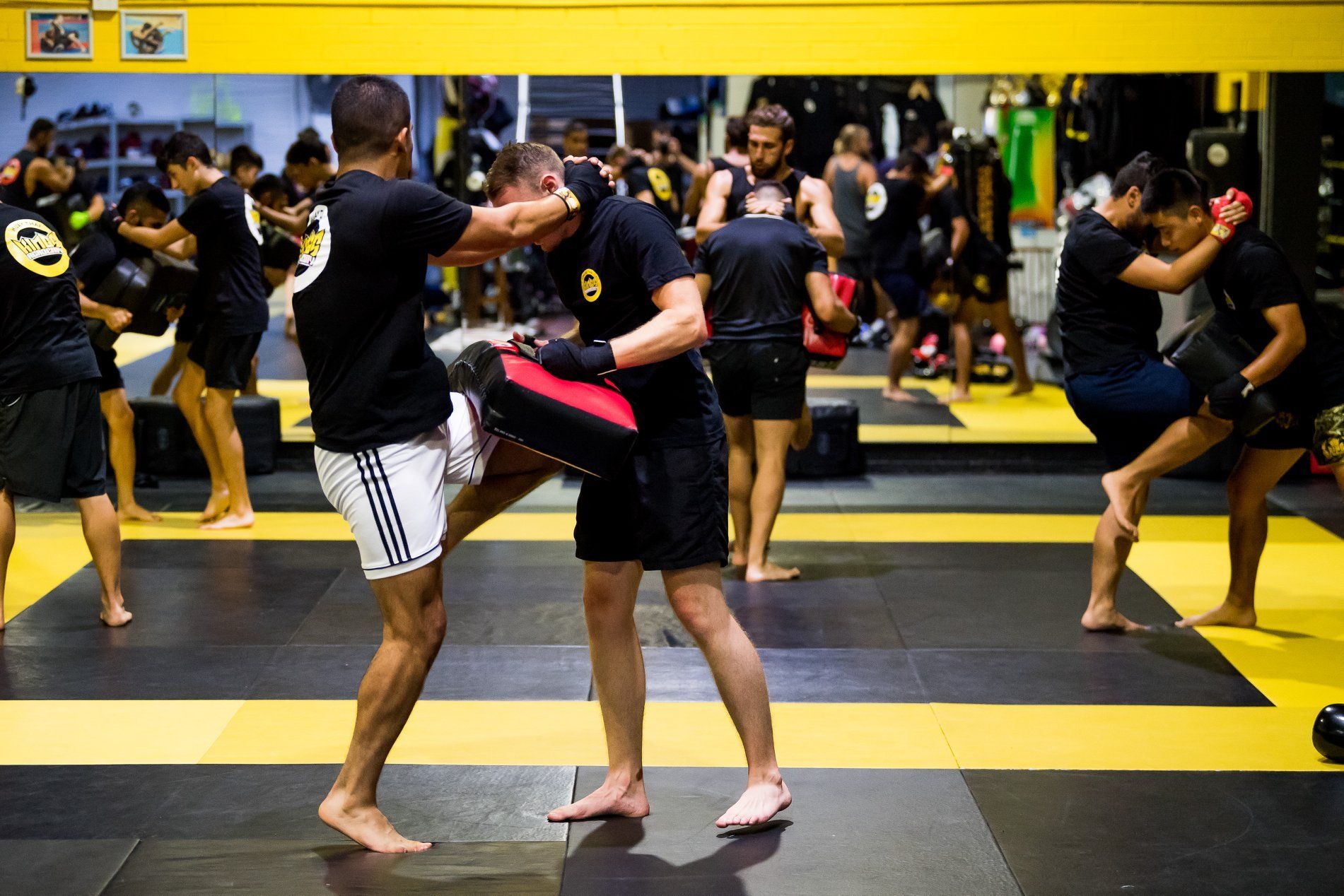 Muay Thai class with partners practicing knees at Kings Academy