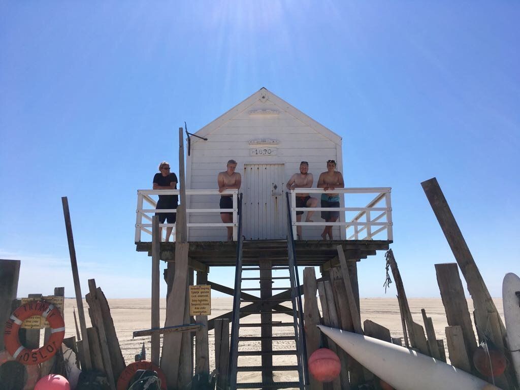 Sunny beach day on Vlieland (Dutch Wadden Islands) with a raised lifeguard post and wide sandy shoreline.