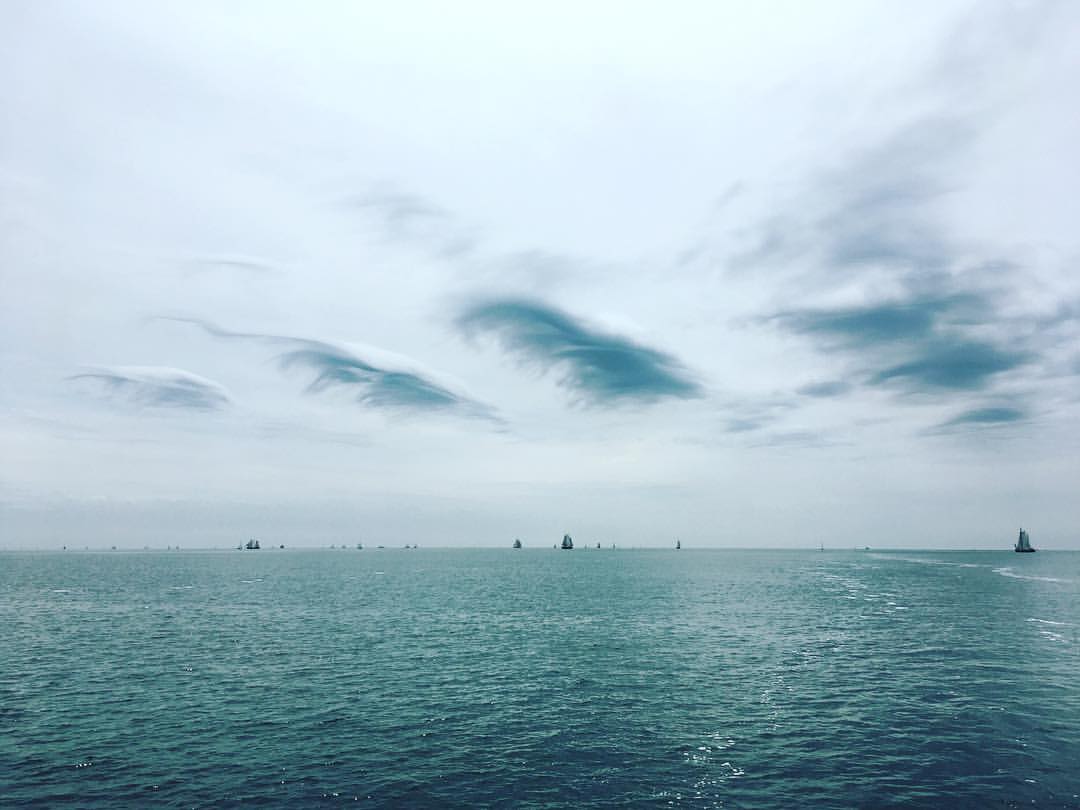 Sea with sailboats under a grey sky, a classic Dutch sailing day near the Wadden Sea.