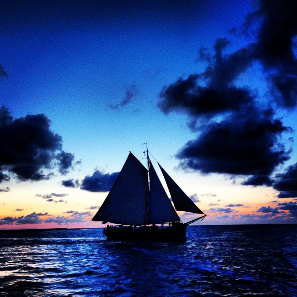 Sailing ship Lauwerszee cruising at dusk on the Dutch Wadden Sea under a dramatic sky.