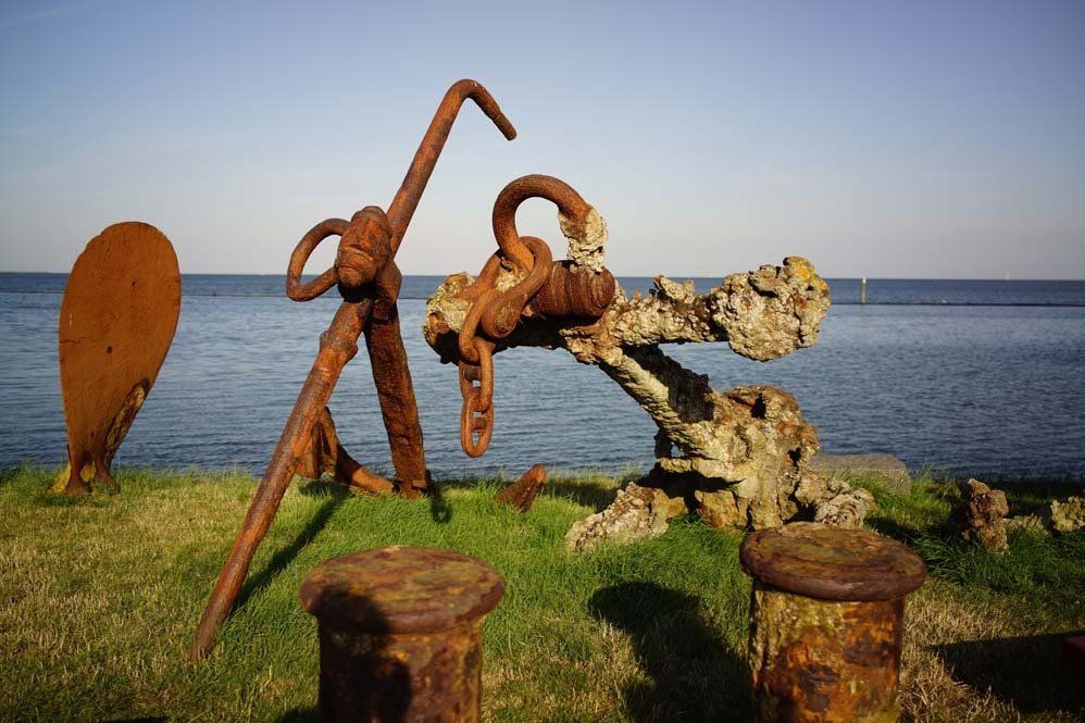Weathered anchors on the grass by the sea on Terschelling, one of the Dutch Wadden Islands.
