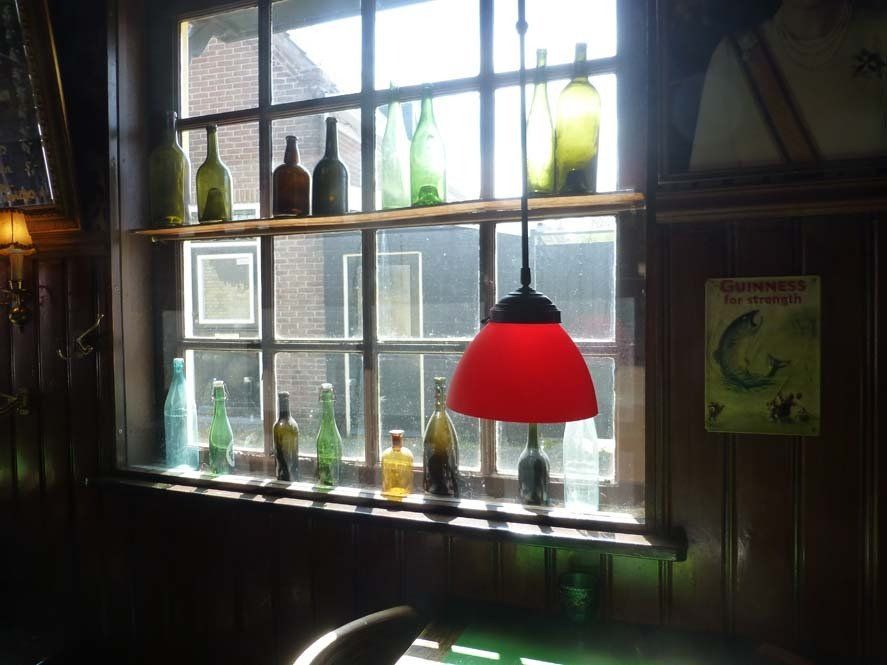 Cosy café interior in West-Terschelling (Dutch Wadden Islands) with bottles, warm lighting and local character.