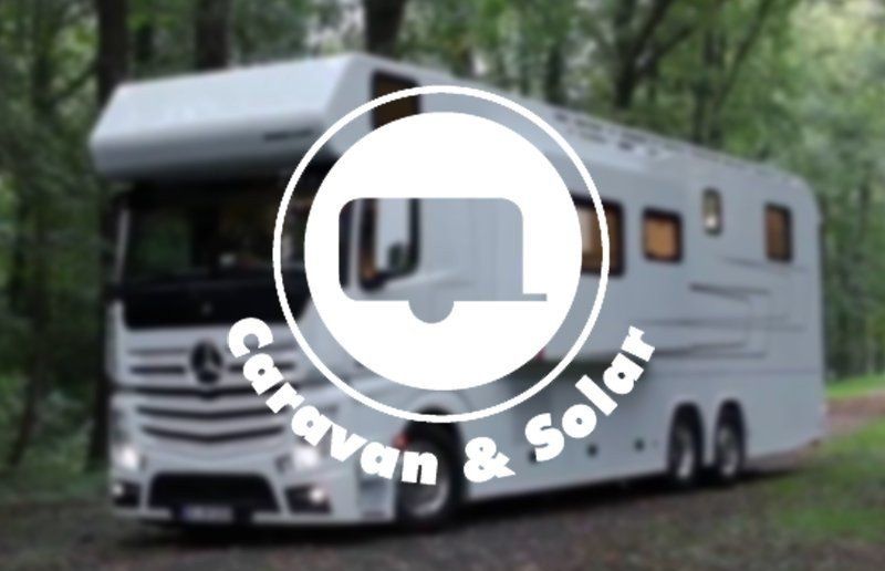White caravan on a forest road with a “Caravan & Solar” logo overlay