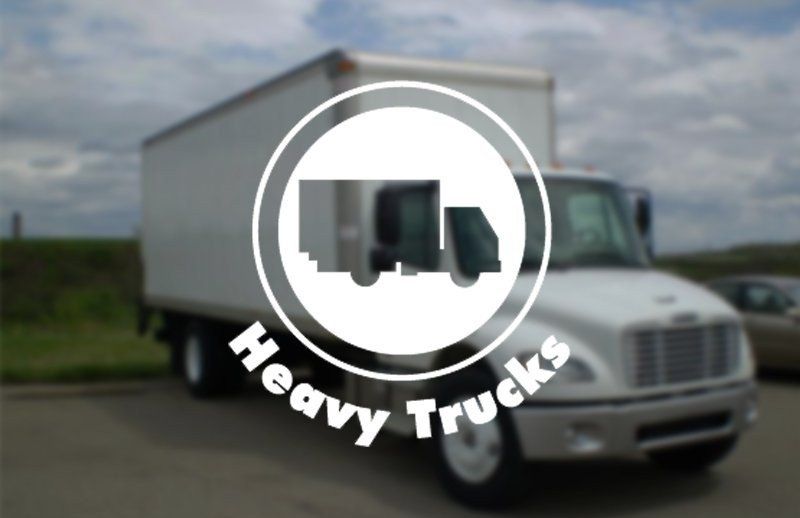 White box truck on a road with a “Heavy Trucks” logo overlay