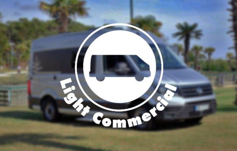 White van logo reading “Light Commercial” on a blurred outdoor background with palm trees
