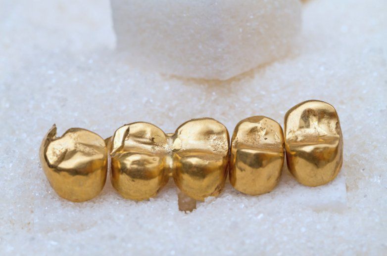 Gold crown on bed of sugar at Kipnis Dental Brighton Beach Brooklyn NY