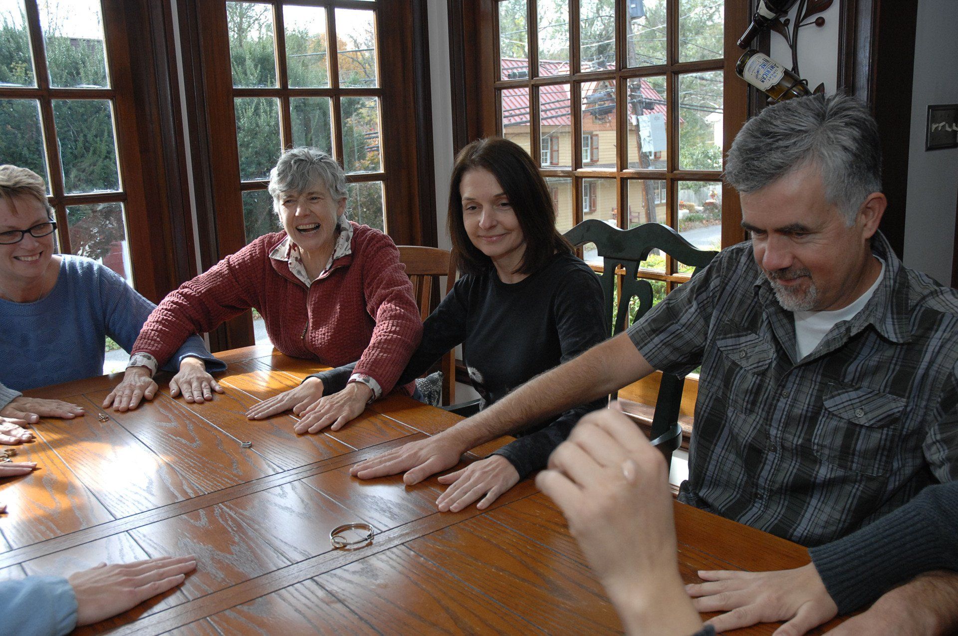 A group of people are sitting around a table with their hands on the table.