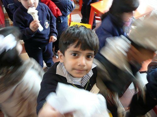 A boy in a school uniform is eating ice cream