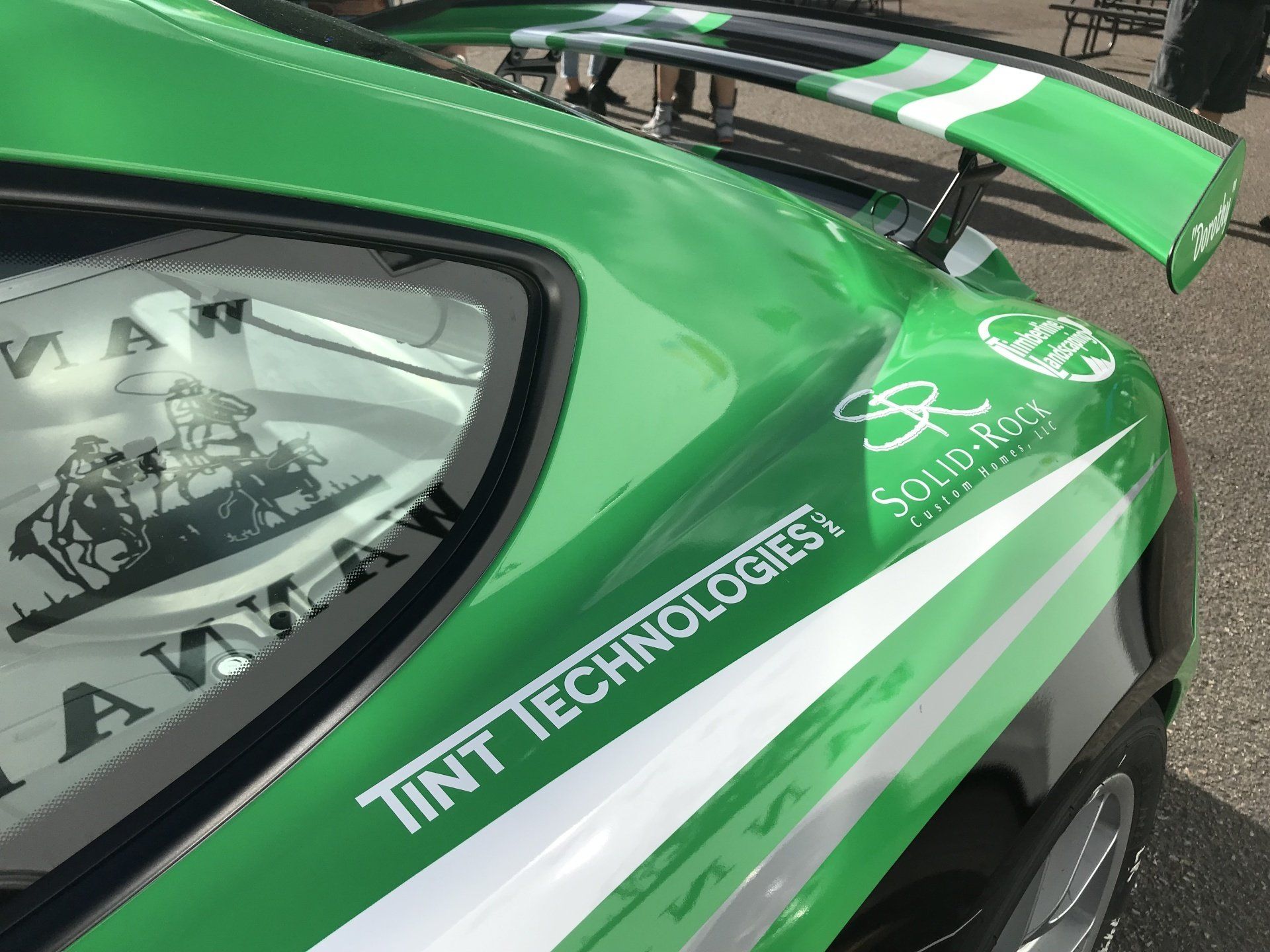A green car with tint technologies written on the side