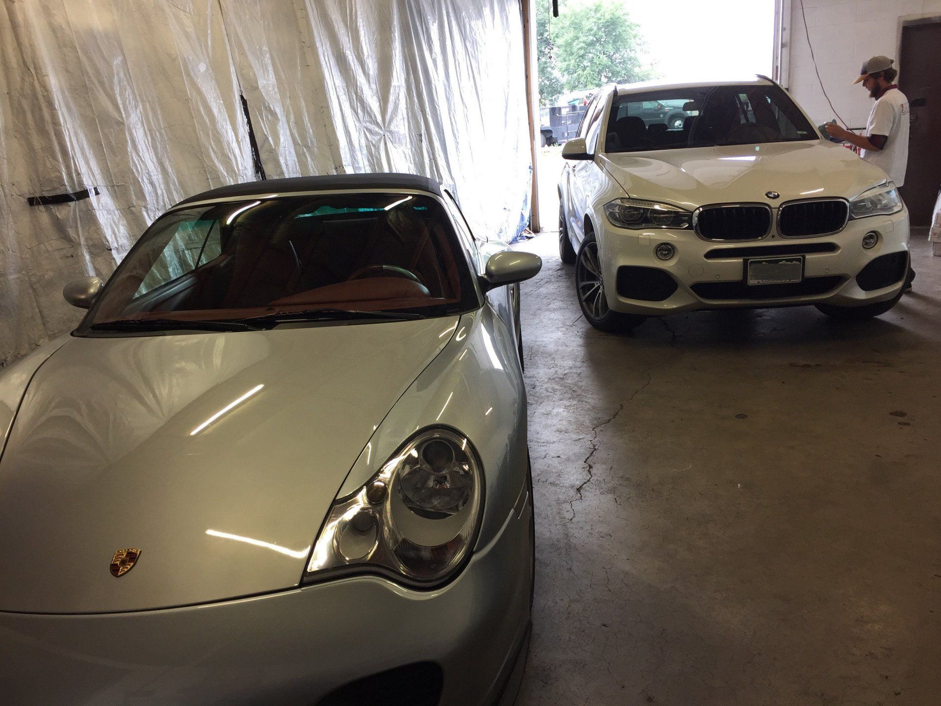 Two cars are parked next to each other in a garage.