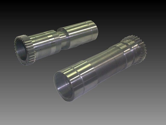 Two metallic cylindrical machine parts with toothed ends and smooth shafts on a gray background.