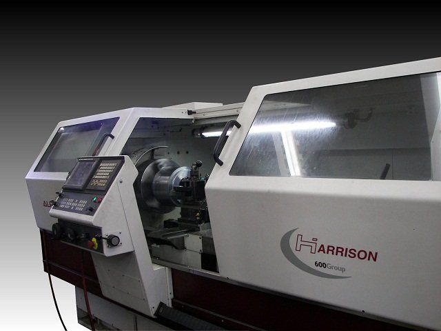 White Harrison lathe machine with open protective cover.
