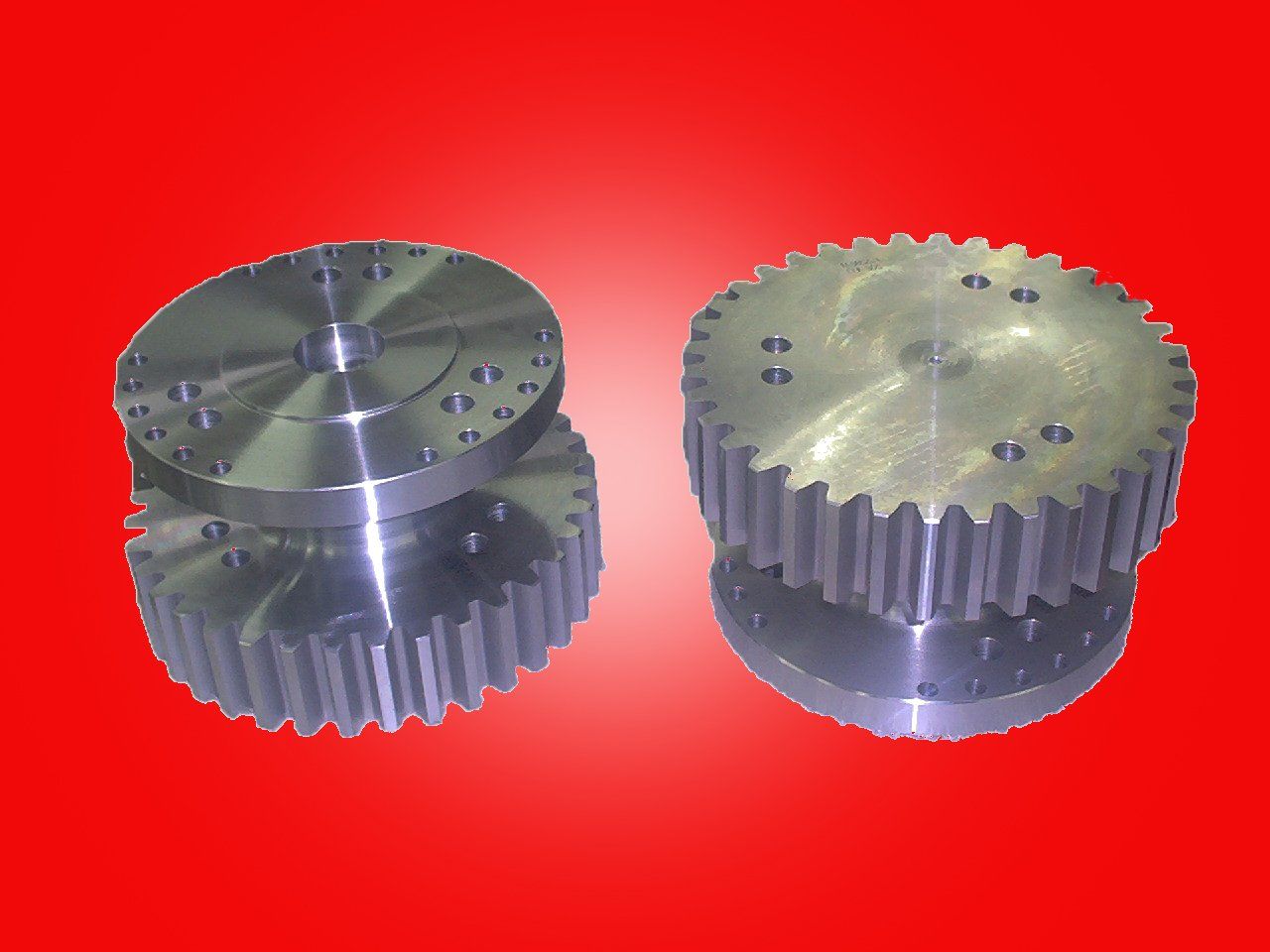 Two metal gears stacked with smaller circular pieces on top, against a red background.
