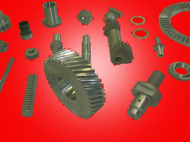 Assortment of metal gears and machine parts against a red gradient background.