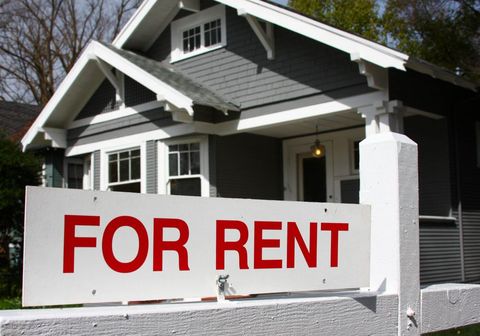 House with for rent sign in front of it