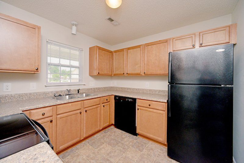 beacon kitchen with brown cabinets and black appliances