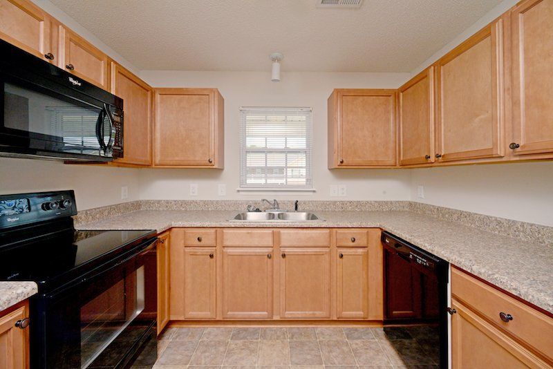 beacon kitchen with brown cabinets and black appliances